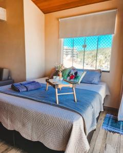 a bedroom with a bed with a table on it at Casamar Lofts Praia dos Anjos 03 in Arraial do Cabo