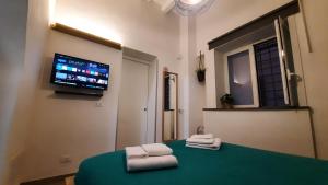 Habitación con 2 toallas en una mesa y TV. en Holiday Home Celsus 84 en Palermo