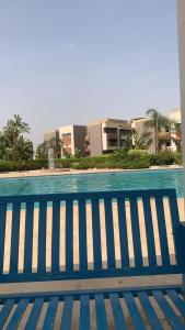 um banco azul sentado ao lado de uma piscina em شقه فندقية للإيجار بالشيخ زايد em Sheikh Zayed