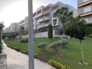a large apartment building with trees in a park at شقه فندقية للإيجار بالشيخ زايد in Sheikh Zayed