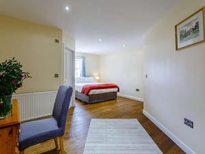 a bedroom with a bed and a chair and a table at 5 Bed in Bishop Auckland 83828 in Wolsingham