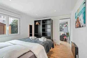 a bedroom with a large bed and a large window at Maison de ville contemporaine avec jardin in Cannes