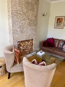 - un salon avec deux chaises et une cheminée dans l'établissement Homely One Bedroom Apartment, à Londres