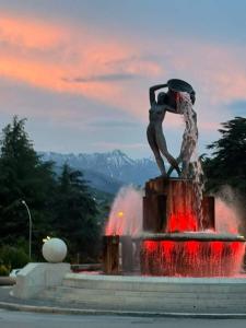 uma estátua de uma mulher sentada em cima de uma fonte em Hotel Grazia Ristorante em LʼAquila