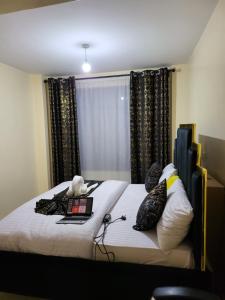 a bedroom with a bed with a laptop and pillows at G&G Homes Executive Suite in Nakuru