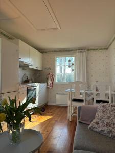 een keuken en een woonkamer met een bank en een tafel bij Gästhus i gårdsmiljö in Forsheda