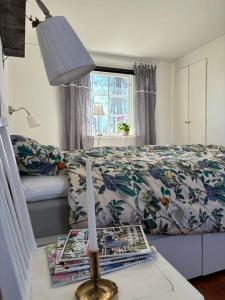 een slaapkamer met een bed en een tafel met een lamp bij Gästhus i gårdsmiljö in Forsheda