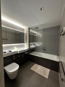 La salle de bains est pourvue de toilettes, d'un lavabo et d'une baignoire. dans l'établissement Battersea power station, à Londres