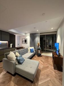 uma sala de estar com um sofá e uma televisão em Battersea power station em Londres