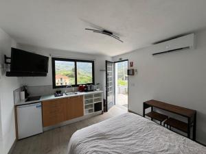 a bedroom with a bed and a kitchen with a sink at GuestReady - Tranquil Retreat in Nature's Embrace in São Vicente
