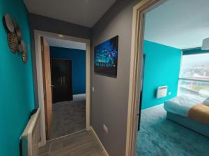 Cet appartement comprend une chambre dotée de murs bleus et d'un miroir. dans l'établissement 2br Stunning City Centre Apt, à Belfast