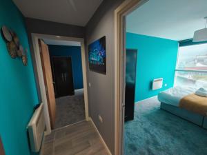 1 dormitorio con paredes azules, espejo y cama en 2br Stunning City Centre Apt en Belfast