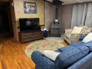 sala de estar con sofá azul y TV en Bourbon Trail Hideaway en Frankfort