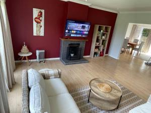 a living room with a white couch and a fireplace at Graceful Getaway in Grahamstown
