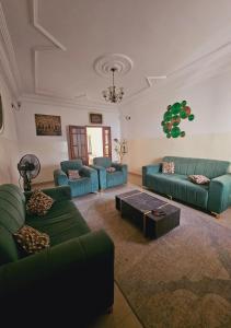 a living room with green couches and a coffee table at MAISON MOUnADJA in Dakar