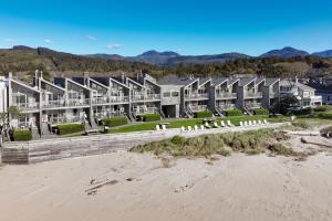 - un grand bâtiment sur la plage à côté du sable dans l'établissement Schooner's Cove Inn, à Cannon Beach