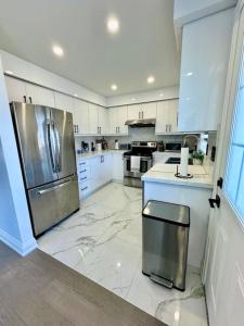 a kitchen with white cabinets and a stainless steel refrigerator at Private Luxury Full Home in Markham in Markham