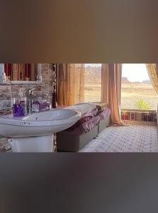 a bathroom with a sink and a bed and a window at Dream Bedouin life camp in Wadi Rum