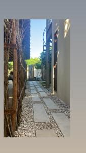 a stone walkway next to a building with a fence at Kanau Surfe e Arte in Marechal Deodoro