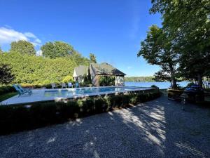 uma casa com piscina ao lado de um lago em Bluebird Sanctuary - Howe island Luxury Retreat em Pittsburgh