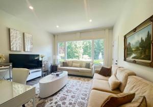 uma sala de estar com um sofá e uma televisão em Bluebird Sanctuary - Howe island Luxury Retreat em Pittsburgh