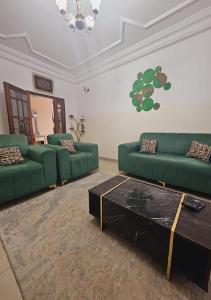 a living room with two green couches and a coffee table at MAISON MOUnADJA in Dakar