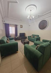 a living room with green couches and a couch at MAISON MOUnADJA in Dakar
