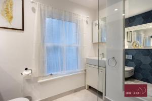uma casa de banho com um chuveiro, um WC e uma janela. em 1 Bedroom Apartment - Central Richmond-upon-Thames em Richmond upon Thames