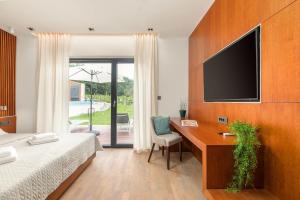 een slaapkamer met een bed en een bureau met een televisie bij Villa Istria Green in Kršan