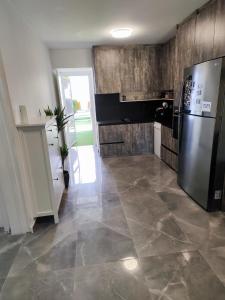 a kitchen with a refrigerator and a tile floor at Pampering Beach Dream, A Stunning Luxury Retreat in Meneou