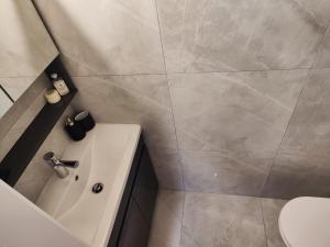 a bathroom with a tub and a toilet and a sink at Pampering Beach Dream, A Stunning Luxury Retreat at Yialos Village in Meneou +26 photos