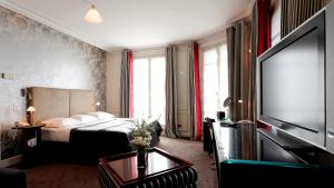 パリにあるラ トレモワイユ パリのベッド1台、薄型テレビが備わるホテルルームです。