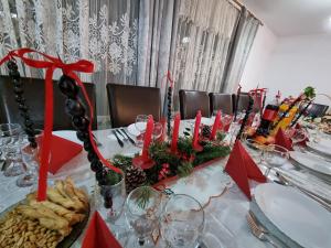 VidraにあるPensiune La Becuのクリスマス食べ物と赤いろうそくがついたテーブル