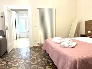 une chambre d'hôtel avec un lit et des serviettes. dans l'établissement Antiche Mura Apartments"Bianco di Puglia" cucina 1 camera da letto più divano letto, à Turi