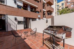 un patio con sillas y una parrilla en un edificio en Departamento en Obispo Trejo by Lofty en Córdoba