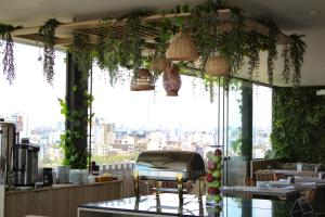 a restaurant with plants hanging from the ceiling at Palmetto Hotel Business San Miguel in Lima