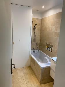 La salle de bains est pourvue d'une baignoire et d'une douche. dans l'établissement Maison idéalement située à Versailles, à Versailles