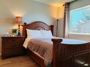 a bedroom with a wooden bed with a lamp and a window at Better Bed in Richmond