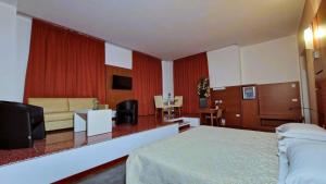 a hotel room with a bed and a living room at Bella Italia Palace Hotel in Novara