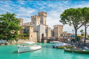 a castle with boats in the water in front of it at Residence il Cascinale in Peschiera del Garda