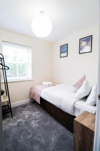 een slaapkamer met een bed en een raam bij 3BR House with Parking near Iron Pier Thames River in Woolwich