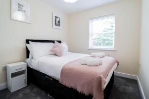 una camera da letto con un letto con lenzuola bianche e una finestra di 3BR House with Parking near Iron Pier Thames River a Woolwich
