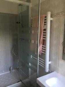 La salle de bains est pourvue d'une douche en verre, d'un lavabo et d'une baignoire. dans l'établissement Maison idéalement située à Versailles, à Versailles