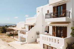 un edificio bianco con scale e balcone di Eclipse Studios Naxos ad Agia Anna Naxos