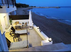 un patio con una mesa y una sombrilla en la playa en Seaside Luxury Komi Beach Villa, en Kómi