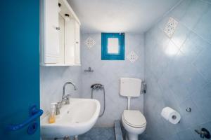 uma casa de banho com um WC branco e um lavatório. em Alcyone em Serifos Chora