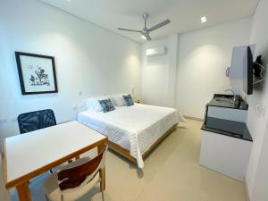a bedroom with a bed and a table and a desk at Apartaestudio Brumilo 2 in Montería