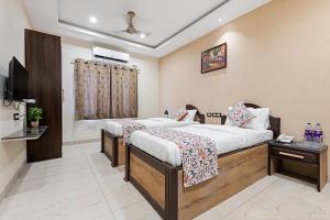 ein Hotelzimmer mit 2 Betten und einem TV in der Unterkunft VEERA RESIDENCY in Tiruvallūr