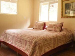 ein Bett in einem Schlafzimmer mit zwei Kissen darauf in der Unterkunft 5th Street Ohana in Volcano