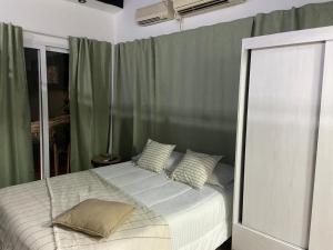 1 dormitorio con cama blanca y cortinas verdes en ! STAR ! in 